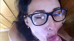 Hot babe with glasses gets her face splattered with cum