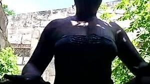 Dark-skinned beauty flaunts her assets outdoors