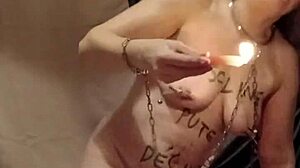 Slave endures self-bondage and wax play outdoors