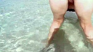 Chubby milf with sexy ass pissing outdoors in water - wanna watch her curves?
