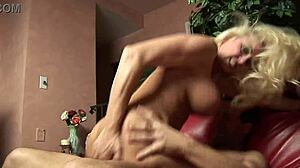 Busty mature blonde stops guy from watching football to ride his cock hard